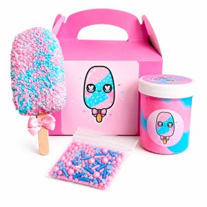 May include: A pink gift box, a jar, and a popsicle are featured in this image. The popsicle is covered in pink and blue sprinkles. The jar and box have a cartoon popsicle design. A small bag of sprinkles is also included.