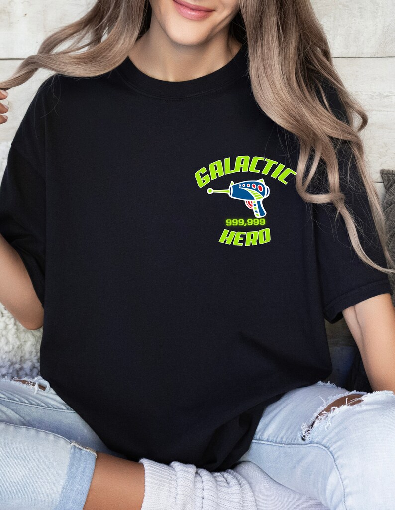 May include: A black t-shirt with a green and blue graphic of a space gun and the text "GALACTIC 999,999 HERO".