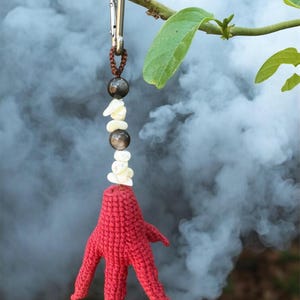 May include: A white ceramic mug with a black handle and the text "But First, Coffee" in a bold, black font. The mug is set against a blurred background, suggesting a cozy setting.