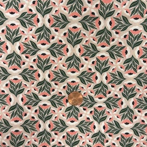 Puede incluir: Una tela con un patrón floral repetitivo de hojas y tallos verde oscuro, pétalos rosa claro y centros negros sobre un fondo beige. Una moneda de cobre está colocada sobre la tela para mostrar la escala del estampado.