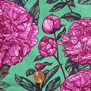 Puede incluir: Primer plano de una tela con un estampado floral. Grandes peonías rosas con contornos rosa oscuro y hojas verdes sobre un fondo verde claro. Se incluye una moneda para la escala.