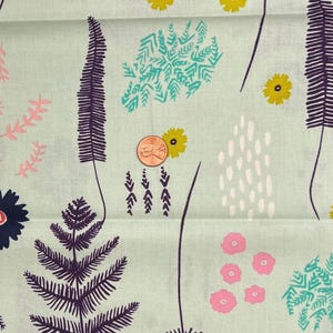 以下が含まれることがあります： 淡い緑色の生地に、様式化された植物と花の繰り返し模様。デザインには、濃い紫色のシダのような形、黄色とピンクの花、ターコイズと白のアクセントが含まれています。スケールを示すためにペニーが含まれています。