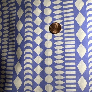 May include: A blue fabric with a white geometric pattern. The pattern includes circles, diamonds, crescents, and rectangles.