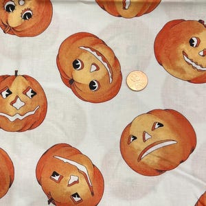 May include: White fabric with a repeating pattern of orange jack-o'-lantern faces. The jack-o'-lanterns have different facial expressions, including smiling, frowning, and surprised.