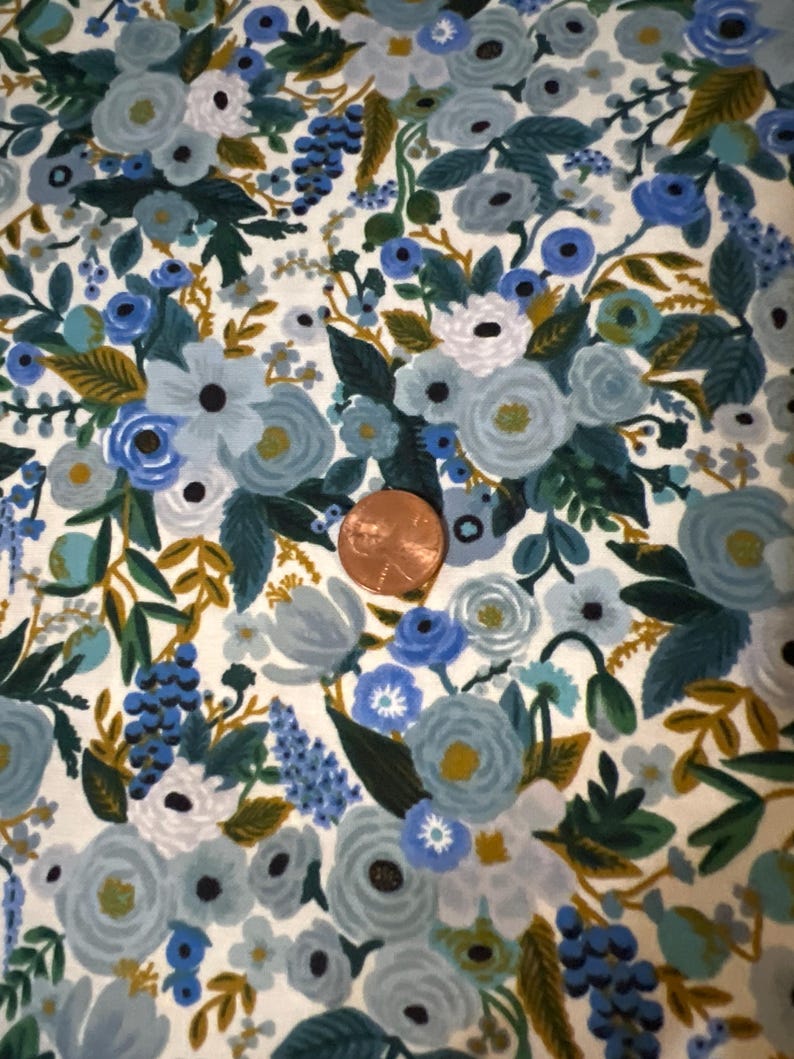Puede incluir: Tela blanca con un patr&oacute;n floral azul y verde. La tela presenta una variedad de flores, hojas y enredaderas. Las flores son en tonos de azul, verde y blanco. Las hojas son en tonos de verde y marr&oacute;n. Las enredaderas son en tonos de verde y marr&oacute;n.