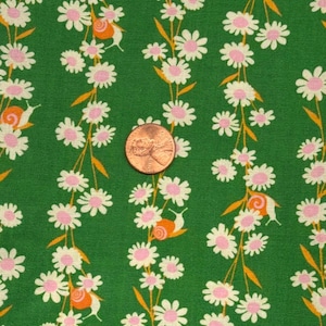 May include: Green fabric featuring a floral pattern of white daisies with pink centres and orange accents. Small orange snails are interspersed among the flowers. A penny is in the centre of the image.