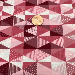 May include: Pink and red geometric patterned fabric with a variety of small designs, including circles, stripes, and dots.