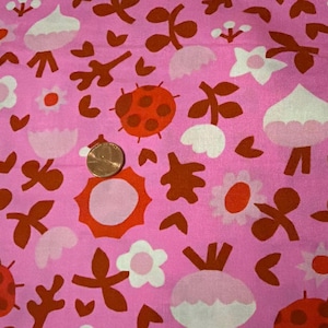 May include: A pink fabric featuring a repeating pattern of red ladybugs, white and orange flowers, and brown leafy stems. A copper-colored penny is placed on the fabric to provide a sense of scale for the printed design elements.
