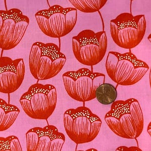 May include: Pink fabric featuring a repeating pattern of red tulip-like flowers. The flowers have white dotted centers and are connected by thin stems. A penny is included for scale.