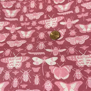 May include: A fabric with a repeating pattern of pink and white insects, including butterflies, moths, and beetles, on a dark pink background. The insects vary in size and are evenly spaced across the fabric.