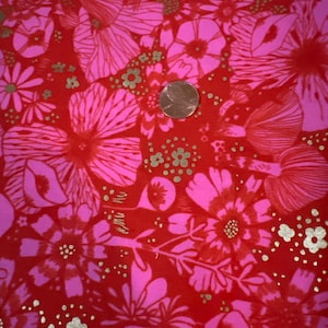 May include: Red fabric with a pink floral pattern and gold glitter accents. The fabric has a vintage feel and would be perfect for a variety of crafting projects.