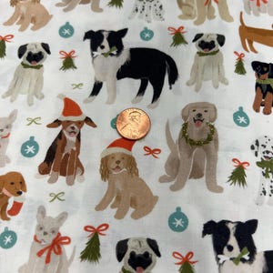 May include: White fabric with a repeating pattern of various dog breeds, including pugs, border collies, and golden retrievers. Some dogs wear Santa hats or wreaths. The design also features Christmas tree accents and snowflakes.