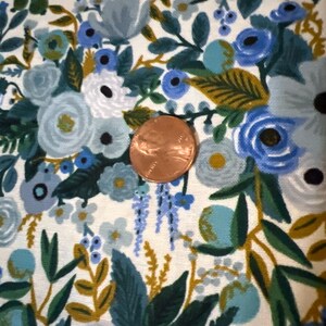 Puede incluir: Una tela blanca con un patr&oacute;n floral azul y verde. La tela presenta una variedad de flores, hojas y bayas. Las flores son en tonos de azul, verde y blanco. Las hojas son en tonos de verde y dorado. Las bayas son en tonos de azul y verde.