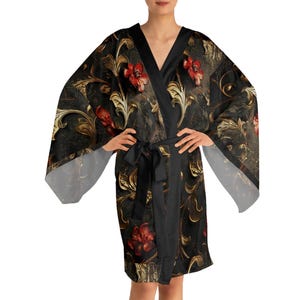May include: A black kimono-style robe with a floral pattern in red and gold. The robe has a black sash and a V-neck design. The sleeves are wide and flowing, and the fabric appears to be silky.