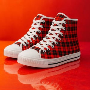 Pu&ograve; includere: Un paio di scarpe alte con un motivo a quadri rosso e nero sulla tomaia in tela. Le scarpe presentano lacci bianchi, punte in gomma bianca e suole in gomma bianca con una sottile striscia nera lungo il lato dell'intersuola.
