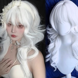 Puede incluir: Una peluca blanca con rizos largos y ondulados y flequillo. La peluca se muestra en una cabeza de maniquí y también la usa una persona. La persona lleva un vestido blanco y un collar de perlas.