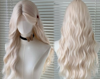 May include: A long, wavy, light blonde wig displayed on a mannequin. The wig features a side part with face-framing layers and a full, voluminous style. The mannequin is wearing a black choker with a butterfly pendant.