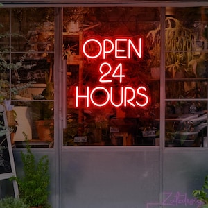 May include: A red neon sign in a shop window reads "OPEN 24 HOURS". The sign is set against a glass door and a display of plants. The shop's name, "Zatzdesign Neon Shop", is visible at the bottom of the image.
