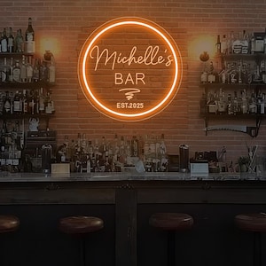 May include: A neon sign for "Michelle's Bar" in a circular orange design. The sign displays the bar's name, a graphic, and the year "EST.2025". It's mounted on a brick wall behind a bar, with bottles and stools visible.