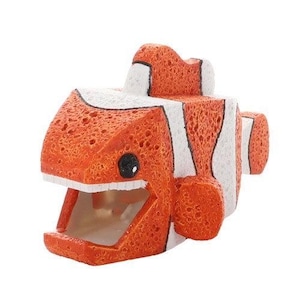Könnte beinhalten: Eine blockartige, würfelförmige Clownfisch-Figur mit einer porösen, schwammartigen Textur. Der Fisch ist in leuchtendem Orange und Weiß gestreift und verfügt über ein weit geöffnetes Maul, ein schwarzes Auge und eine Rückenflosse auf dem Körper.