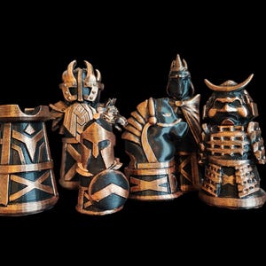 May include: A set of five chess pieces made of black and gold plastic. The pieces include a king, queen, rook, knight, and pawn. The pieces are all in a medieval style.
