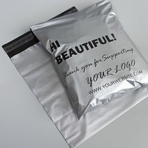 May include: Two silver mailing envelopes with a black stripe across the top. The top envelope has the text "Hi Beautiful! Thank you for supporting YOUR LOGO www.yourwebsite.com" printed in black.