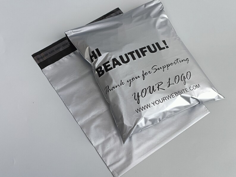 May include: Two silver mailing envelopes with a black stripe across the top. The top envelope has the text "Hi Beautiful! Thank you for supporting YOUR LOGO www.yourwebsite.com" printed in black.
