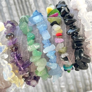 Puede incluir: Una colecci&oacute;n de ocho pulseras de chips de piedras preciosas en varios colores, incluyendo amatista, aguamarina, aventurina verde, obsidiana negra, cuarzo transparente, cuarzo rosa y jaspe amarillo.