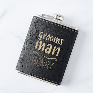May include: Black leather flask with gold lettering that reads "Grooms Man HENRY".