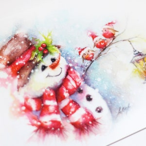 May include: A watercolour painting of a snowman wearing a red and white striped scarf and a brown hat with holly berries. Three red birds with Santa hats are perched on a branch in the background.