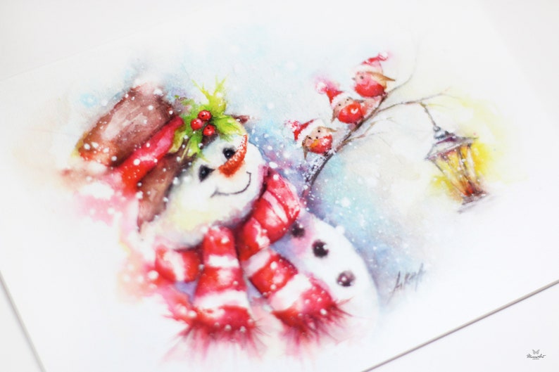 May include: A watercolour painting of a snowman wearing a red and white striped scarf and a brown hat with holly berries. Three red birds with Santa hats are perched on a branch in the background.