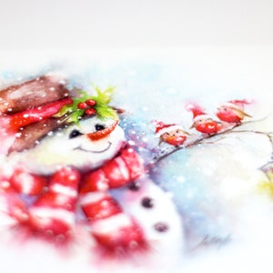 May include: Watercolour painting of a snowman wearing a red and white striped scarf and a brown hat with holly and red berries. Three red birds with Santa hats are perched on a branch in the background.