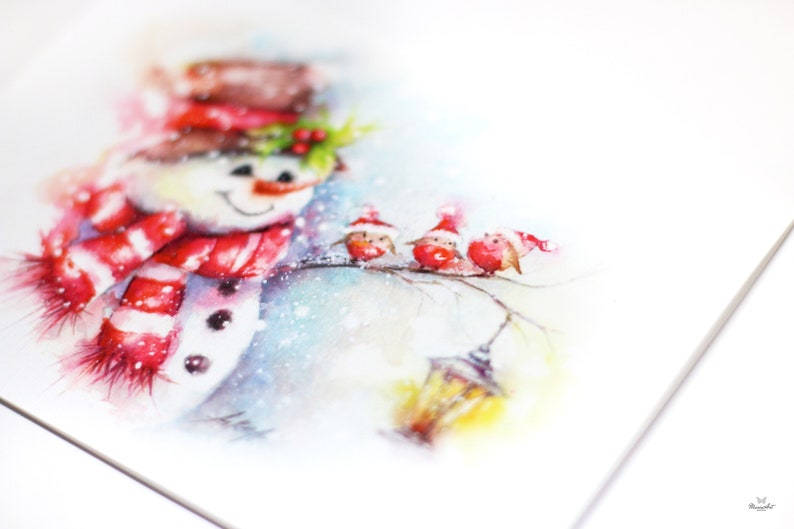 May include: Watercolour painting of a snowman wearing a red and white striped scarf and a red hat. Three red birds are perched on a branch with a yellow lantern in the background.