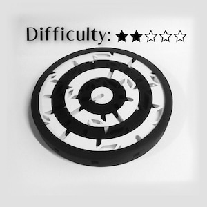 May include: A black and white circular maze with a difficulty rating of four stars. The maze is made of concentric circles with a central hole.