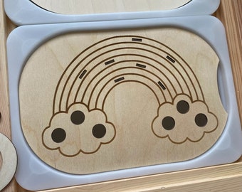 May include: A wooden rainbow with a cutout design, featuring a cloud with three circles on each side. The rainbow is on a light blue tray.