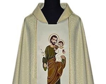 May include: A white and gold liturgical chasuble with an embroidered image of Saint Joseph holding the baby Jesus. The chasuble features a decorative floral design with wheat stalks and grapes.
