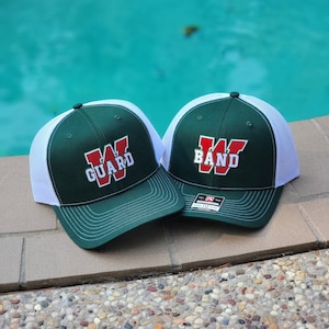 May include: Two green and white baseball caps with a white mesh back. One cap has a red "W" with "GUARD" written below it. The other cap has a red "W" with "BAND" written below it.