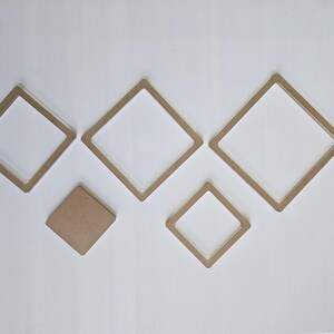May include: A collection of five diamond-shaped wooden frames and a solid diamond shape, arranged on a white surface. The frames vary in size, with a natural wood color.