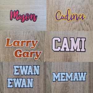 May include: A collection of personalised name patches in various colours and fonts. The names include Mason, Cadence, Larry, Gary, Cami, Ewan, and Memaw.