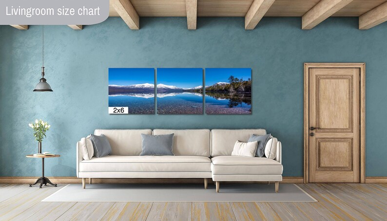 May include: A living room size chart showing a three-panel canvas print of a lake with snow-capped mountains in the background. The print is labeled "2x6" and is displayed above a white couch.