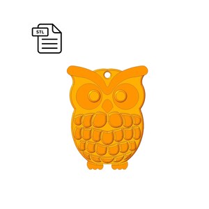 Pode incluir: Um arquivo STL imprimível em 3D para um pingente de coruja dourado. A coruja tem um design detalhado com um corpo texturizado e olhos grandes.