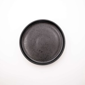 Der Futternapf besteht aus Keramik und hat die ideale Größe. Der Rand ist sehr niedrig um die Schnurrhaare der Katzen nicht zu stören. Die Farbe ist ein schönes Schwarz mit schimmernden Akzenten.