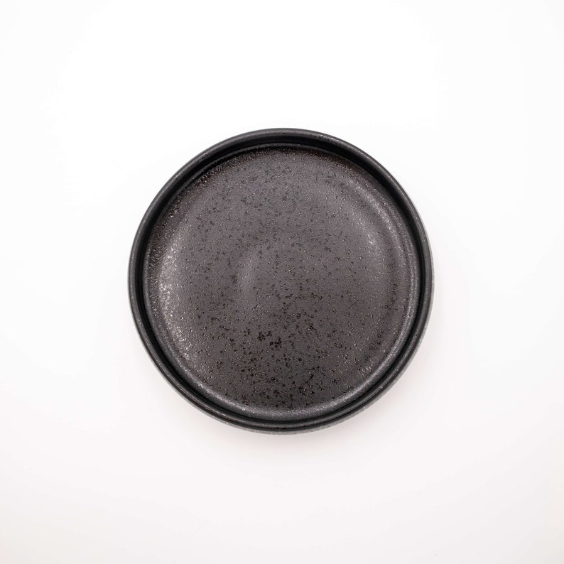 Der Futternapf besteht aus Keramik und hat die ideale Größe. Der Rand ist sehr niedrig um die Schnurrhaare der Katzen nicht zu stören. Die Farbe ist ein schönes Schwarz mit schimmernden Akzenten.