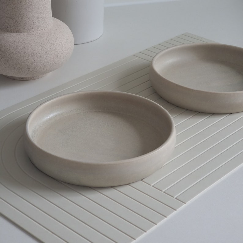 Der Futternapf besteht aus Keramik und hat die ideale Größe. Der Rand ist sehr niedrig um die Schnurrhaare der Katzen nicht zu stören. Die Farbe ist ein natürliches Creme mit schönen scheinenden Akzenten.