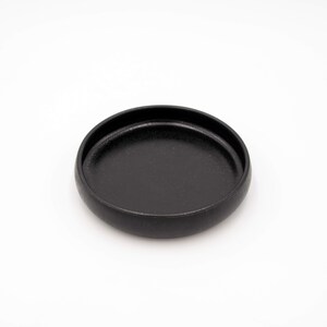 Der Futternapf besteht aus Keramik und hat die ideale Größe. Der Rand ist sehr niedrig um die Schnurrhaare der Katzen nicht zu stören. Die Farbe ist ein schönes Schwarz mit schimmernden Akzenten.