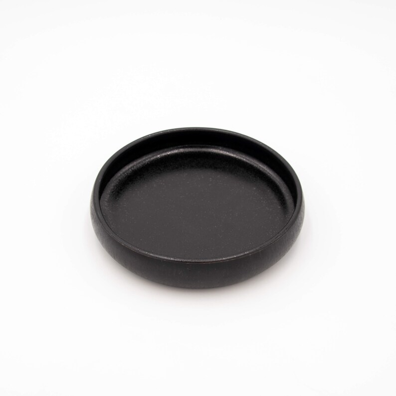 Der Futternapf besteht aus Keramik und hat die ideale Größe. Der Rand ist sehr niedrig um die Schnurrhaare der Katzen nicht zu stören. Die Farbe ist ein schönes Schwarz mit schimmernden Akzenten.