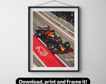 May include: A black and red Formula One race car speeds down a red track with a white number two painted on it.