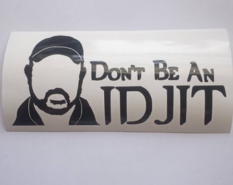 May include: Black and white vinyl decal with a silhouette of a person wearing a hat and the text "Don't Be An IDJIT".