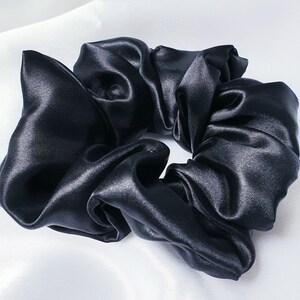 A close up photo of the medium black silky satin scrunchie