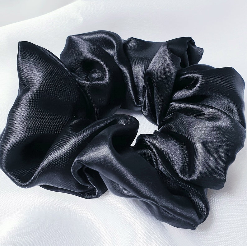 A close up photo of the medium black silky satin scrunchie